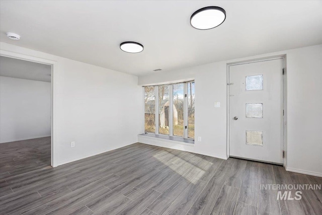 foyer entrance with baseboards and wood finished floors