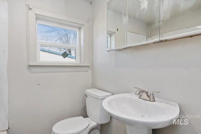 half bathroom featuring a sink and toilet