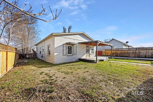 rear view of house with a fenced backyard, a lawn, a patio area, and concrete block siding