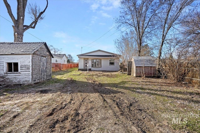 view of yard with an outdoor structure, fence, and a storage shed