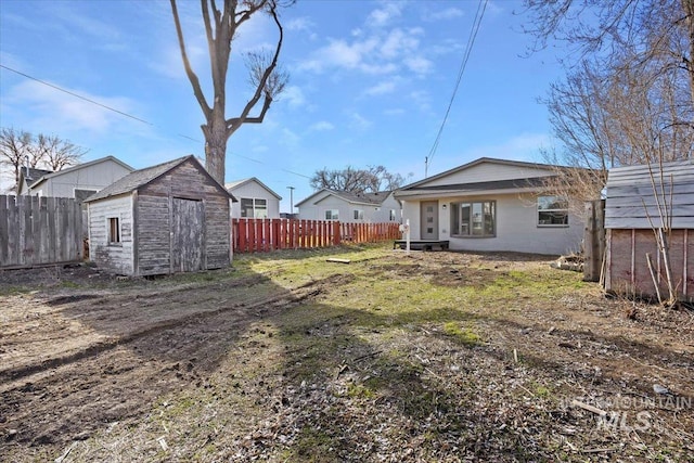 view of yard featuring an outbuilding, fence, and a shed