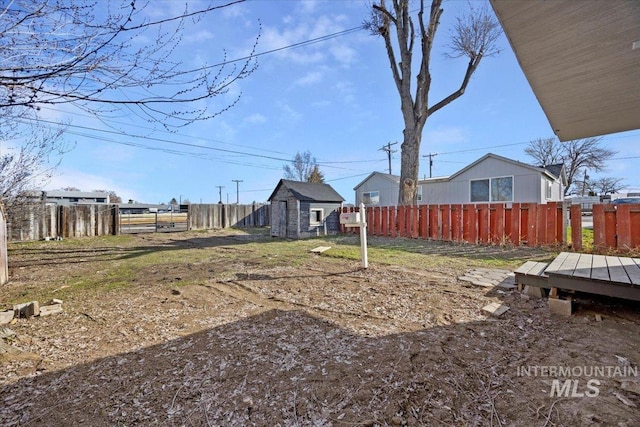 view of yard with an outdoor structure, a fenced backyard, and a storage shed