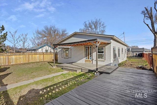 back of property with a lawn, a fenced backyard, and a wooden deck