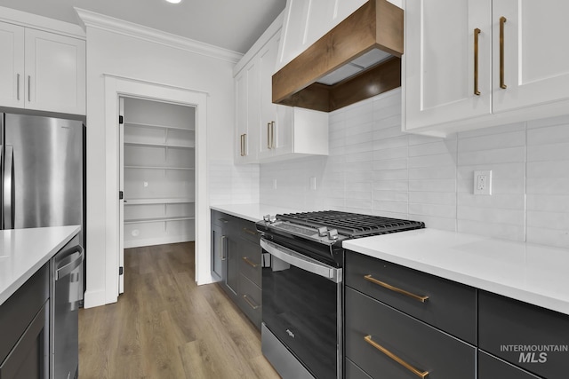 1440 E Azan St, Meridian, ID 83646 - kitchen with ornamental molding, white cabinetry, appliances with stainless steel finishes, light countertops, and premium range hood