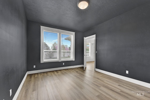 1440 E Azan St, Meridian, ID 83646 - spare room with baseboards, a textured ceiling, and wood finished floors