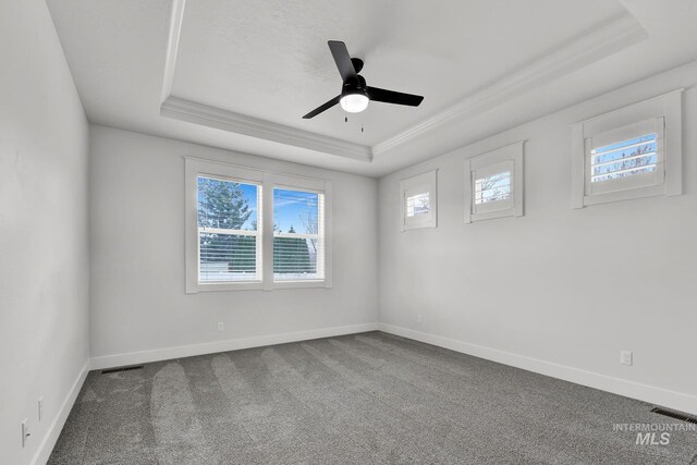 1440 E Azan St, Meridian, ID 83646 - empty room featuring visible vents, baseboards, a raised ceiling, dark colored carpet, and ceiling fan