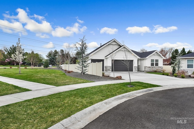 1440 E Azan St, Meridian, ID 83646 - view of front of property featuring a front yard, fence, stone siding, an attached garage, and concrete driveway