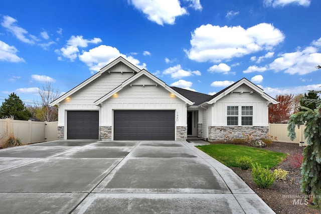 1440 E Azan St, Meridian, ID 83646 - craftsman-style house featuring driveway, fence, stone siding, and a garage