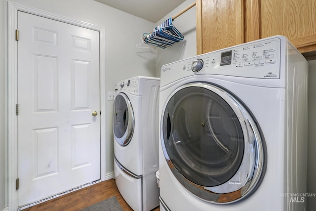 laundry room featuring cabinet space, separate washer and dryer, and dark wood-type flooring