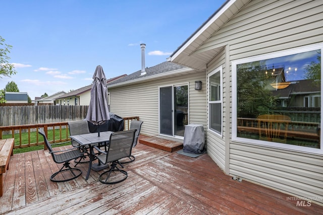 deck featuring outdoor dining area and fence