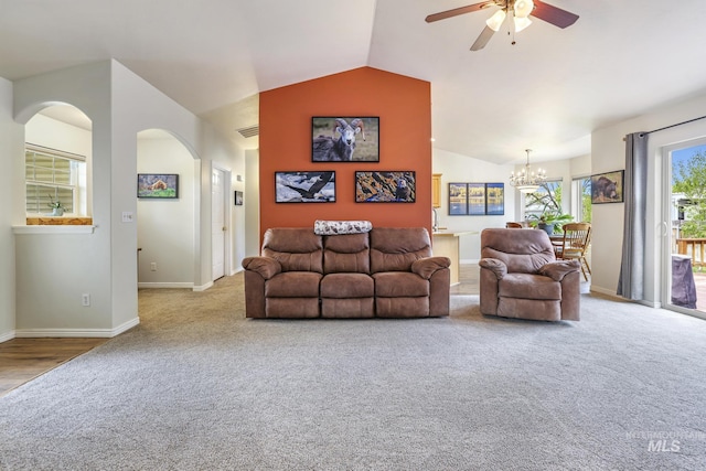 carpeted living room with arched walkways, lofted ceiling, a chandelier, a ceiling fan, and baseboards