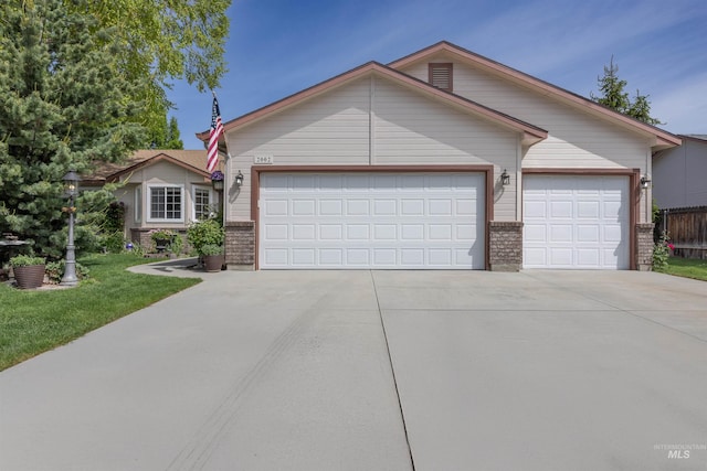 ranch-style home with driveway, a garage, brick siding, and a front yard
