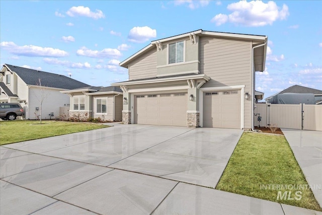 traditional home featuring driveway, a front lawn, a gate, fence, and an attached garage