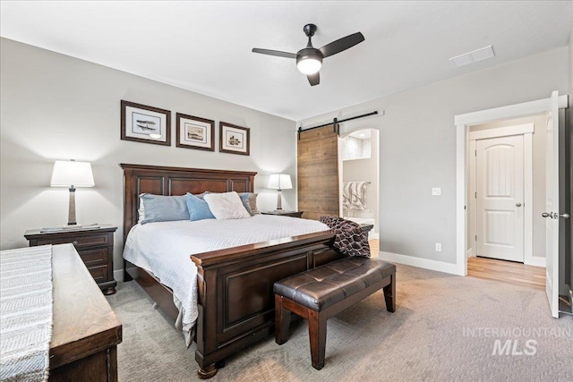 bedroom with a ceiling fan, baseboards, visible vents, light carpet, and a barn door