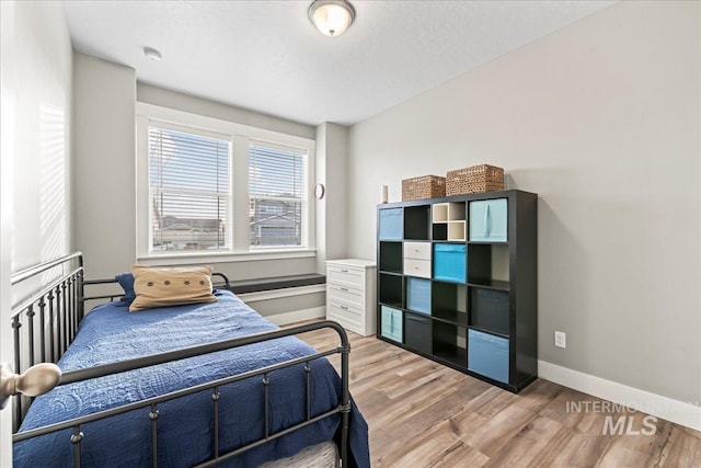 bedroom with light wood-style floors and baseboards