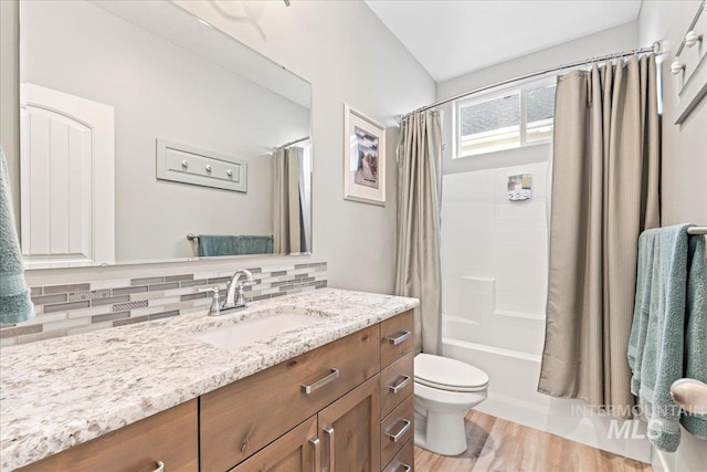 full bath featuring shower / bathtub combination with curtain, toilet, backsplash, wood finished floors, and vanity