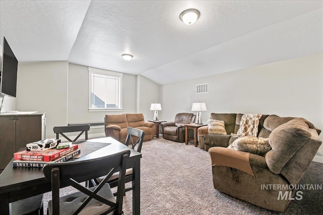 living area with visible vents, carpet floors, a textured ceiling, and vaulted ceiling