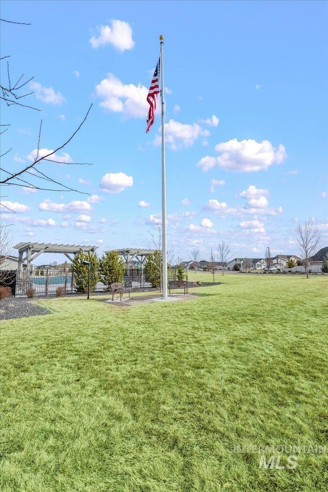 view of home's community featuring a lawn and a pergola