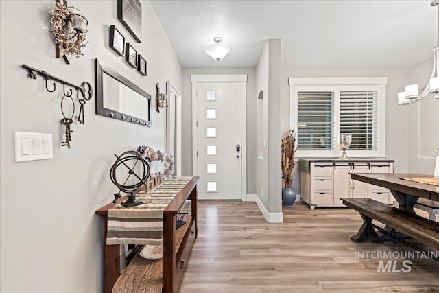 foyer entrance featuring baseboards and light wood finished floors