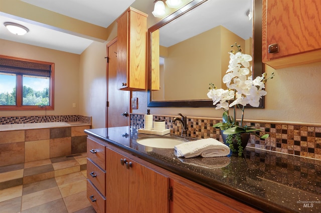 bathroom with tile patterned flooring, backsplash, vanity, and a bath