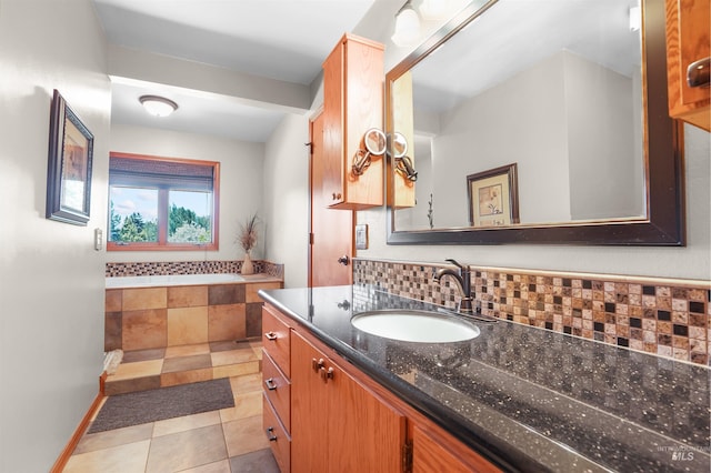 bathroom featuring tasteful backsplash, tile patterned flooring, vanity, and a bath