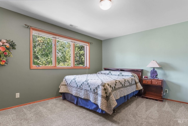 carpeted bedroom featuring visible vents and baseboards