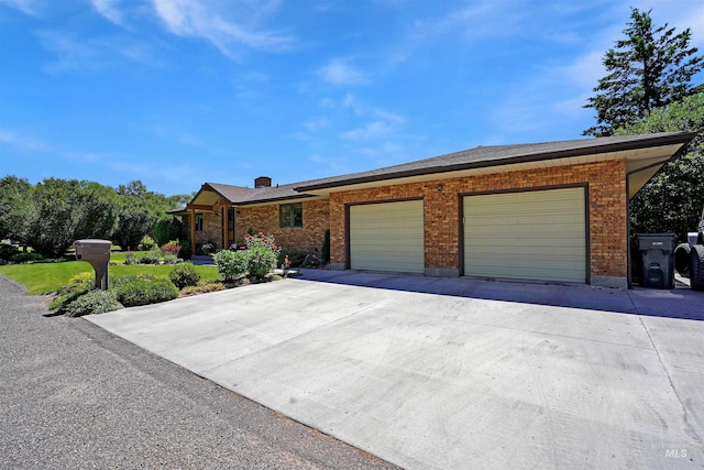 single story home featuring concrete driveway, brick siding, and an attached garage