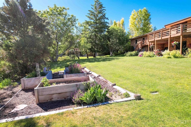 view of yard featuring a garden, a deck, and stairs