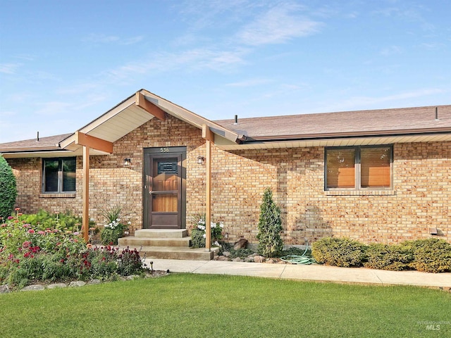 ranch-style house with a front yard and brick siding