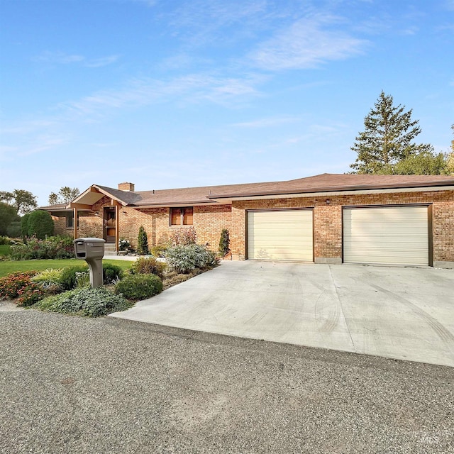 view of front of house featuring a garage, concrete driveway, and brick siding