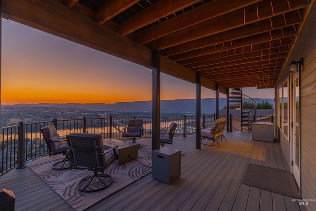 deck at dusk featuring a mountain view and an outdoor living space