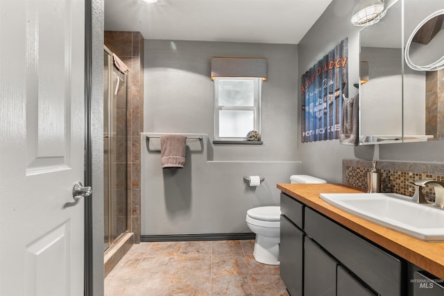 bathroom featuring toilet, an enclosed shower, decorative backsplash, and vanity