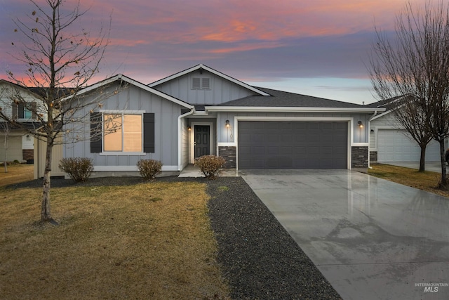 view of front facade with a lawn, driveway, stone siding, board and batten siding, and an attached garage