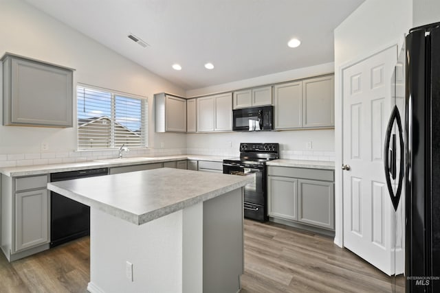 kitchen featuring gray cabinets and black appliances