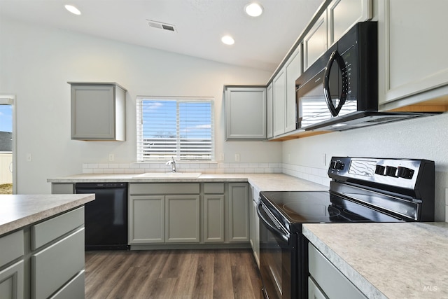 kitchen with gray cabinets, black appliances, and a sink