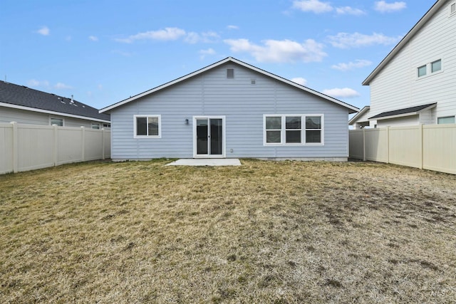 back of property with a fenced backyard, a patio area, and a yard