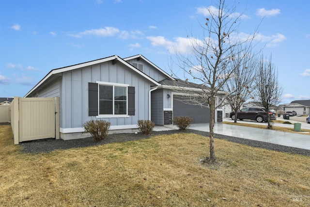 ranch-style house featuring board and batten siding, a front yard, driveway, and a garage