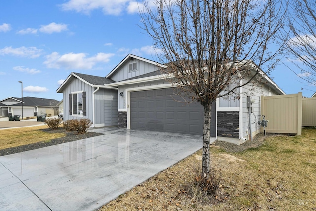 ranch-style home featuring stone siding, board and batten siding, concrete driveway, a front yard, and an attached garage