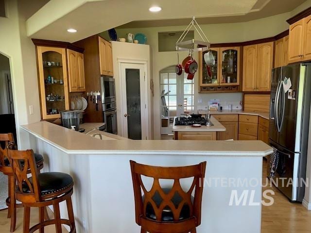 3997 W Harbor Point Dr, Meridian, ID 83646 - kitchen featuring refrigerator with ice dispenser, a kitchen breakfast bar, glass insert cabinets, recessed lighting, and light countertops