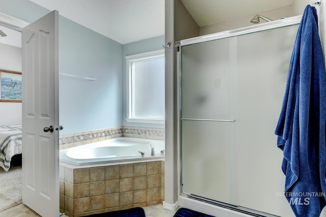 ensuite bathroom featuring connected bathroom, a garden tub, and a shower stall