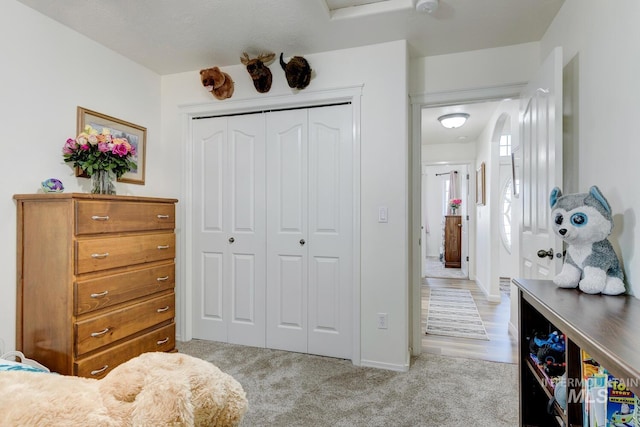 bedroom featuring a closet and light colored carpet