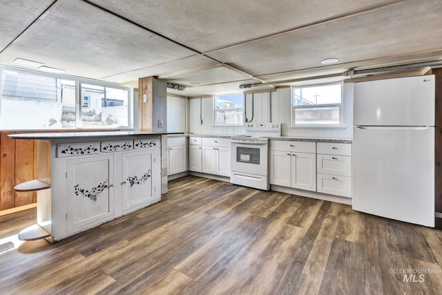 405 N 2nd E, Mountain Home, ID 83647 - kitchen featuring white appliances, dark wood-type flooring, white cabinets, and a peninsula