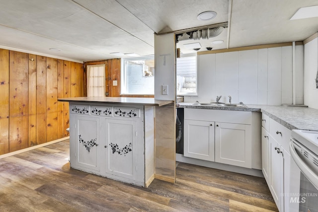 405 N 2nd E, Mountain Home, ID 83647 - kitchen featuring dark wood-type flooring, a sink, white cabinets, electric range oven, and wooden walls