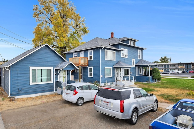 405 N 2nd E, Mountain Home, ID 83647 - view of front of property featuring a chimney, a shingled roof, a balcony, and a front lawn