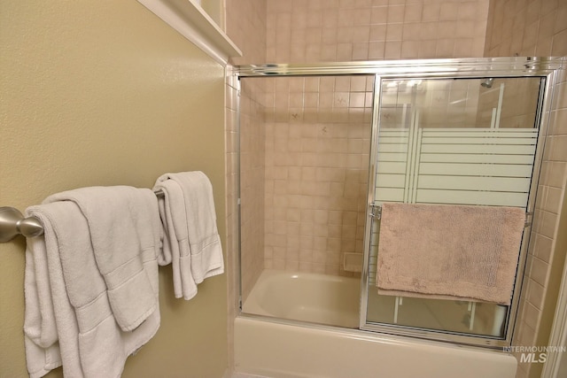 bathroom featuring shower / bath combination with glass door