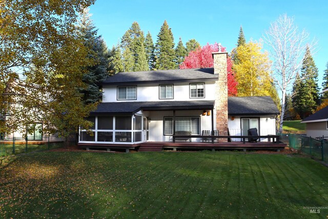 rear view of house featuring a lawn and a wooden deck