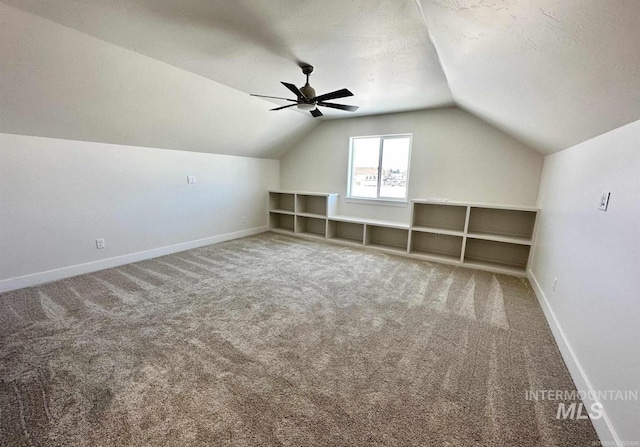 bonus room featuring a textured ceiling, ceiling fan, carpet floors, and lofted ceiling