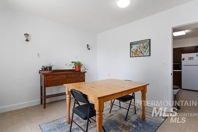 dining area with baseboards and light tile patterned flooring