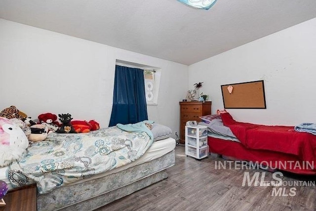 bedroom featuring lofted ceiling and wood finished floors