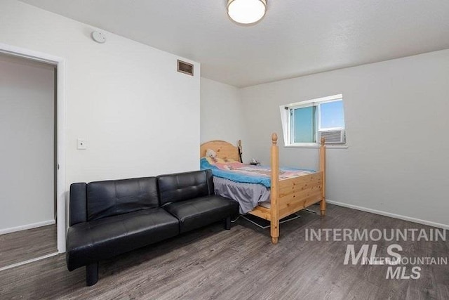 bedroom featuring wood finished floors, baseboards, and visible vents